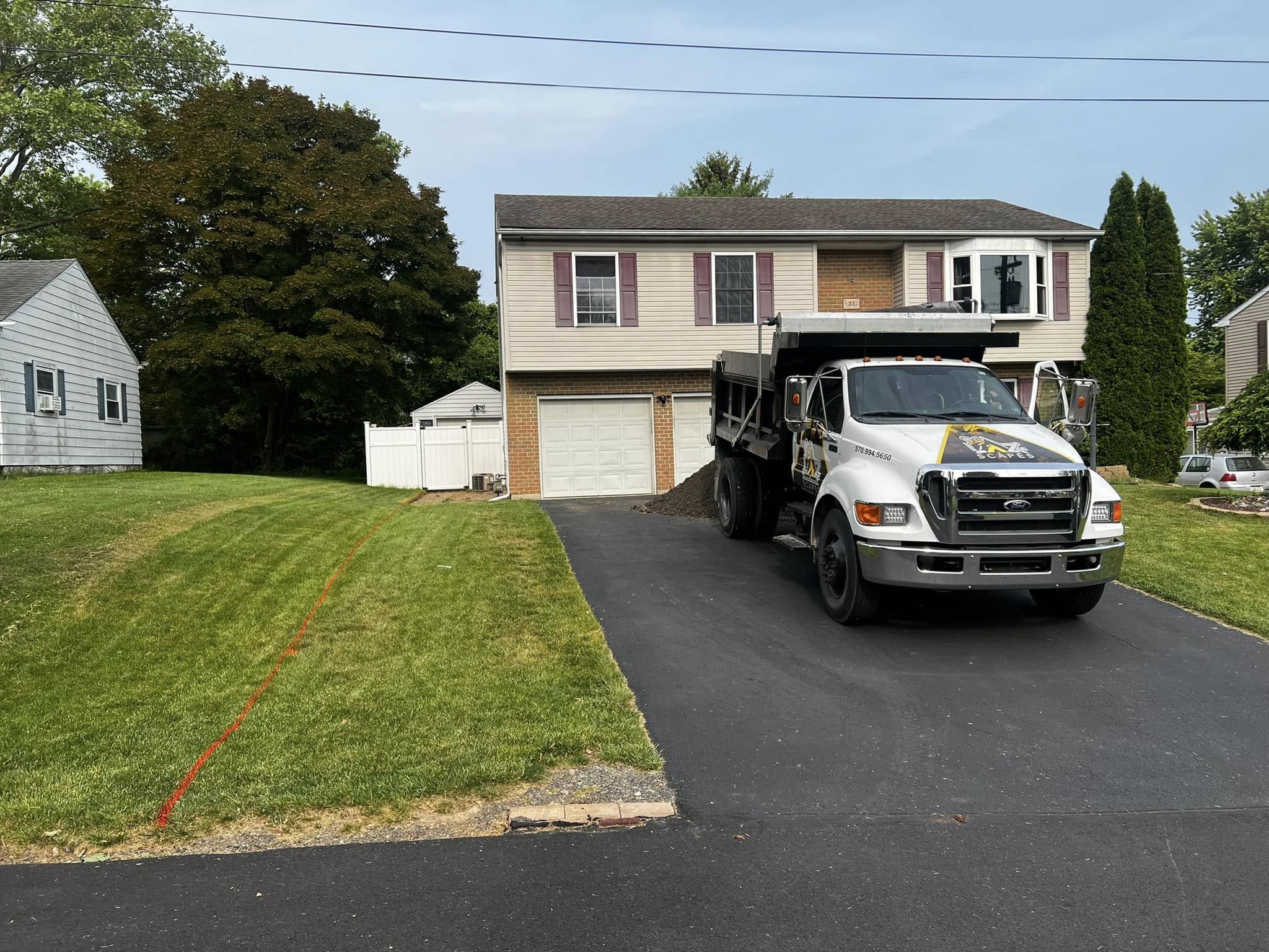 Cornerstone Hardscapes dump truck on a freshly paved driveway