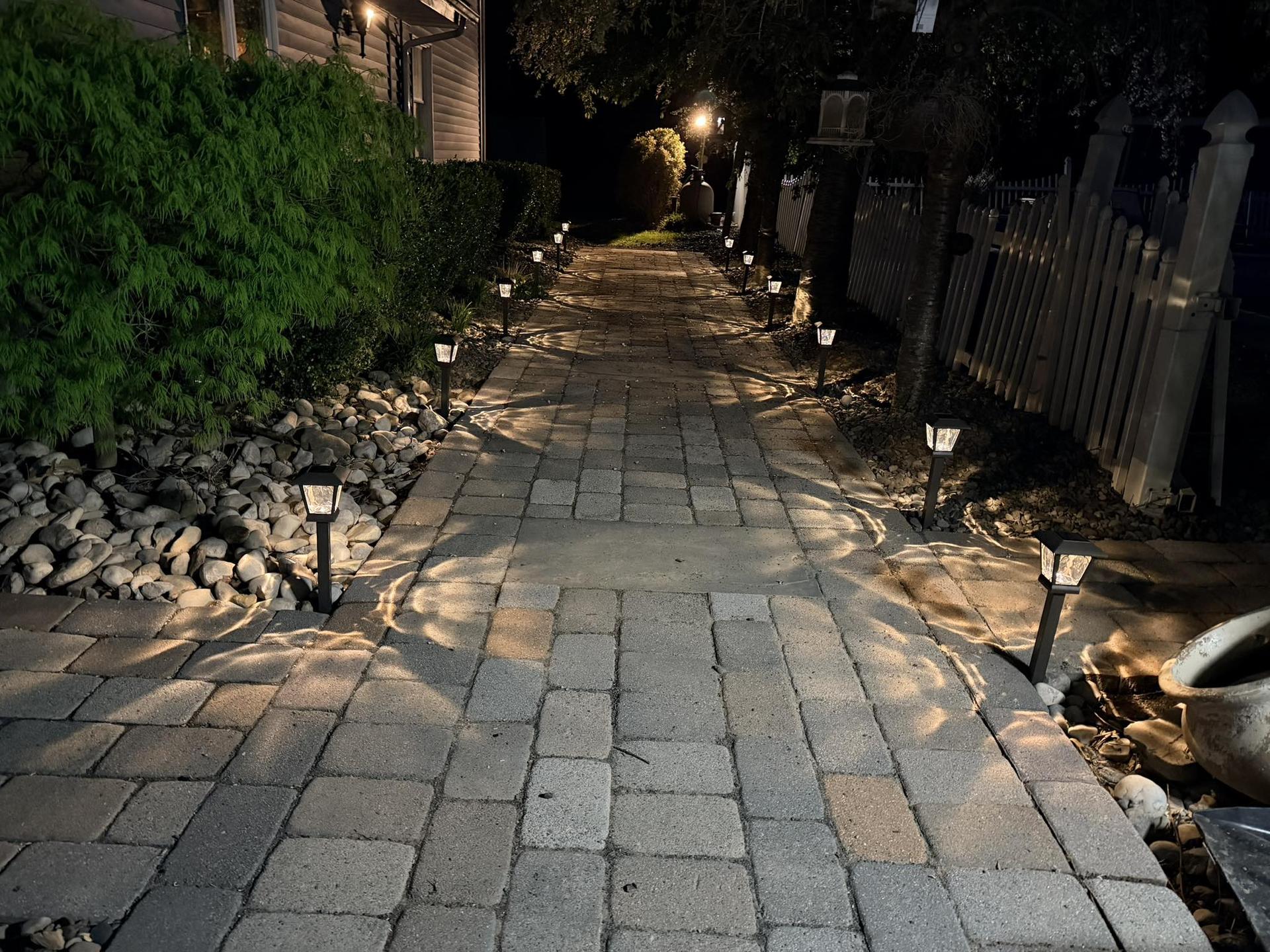 Walkway with landscape lighting at dusk